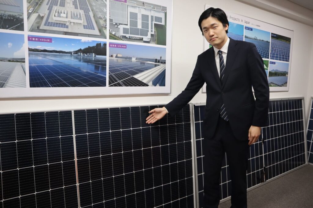 太陽電池モジュールを指さすリープトンエナジーの社員