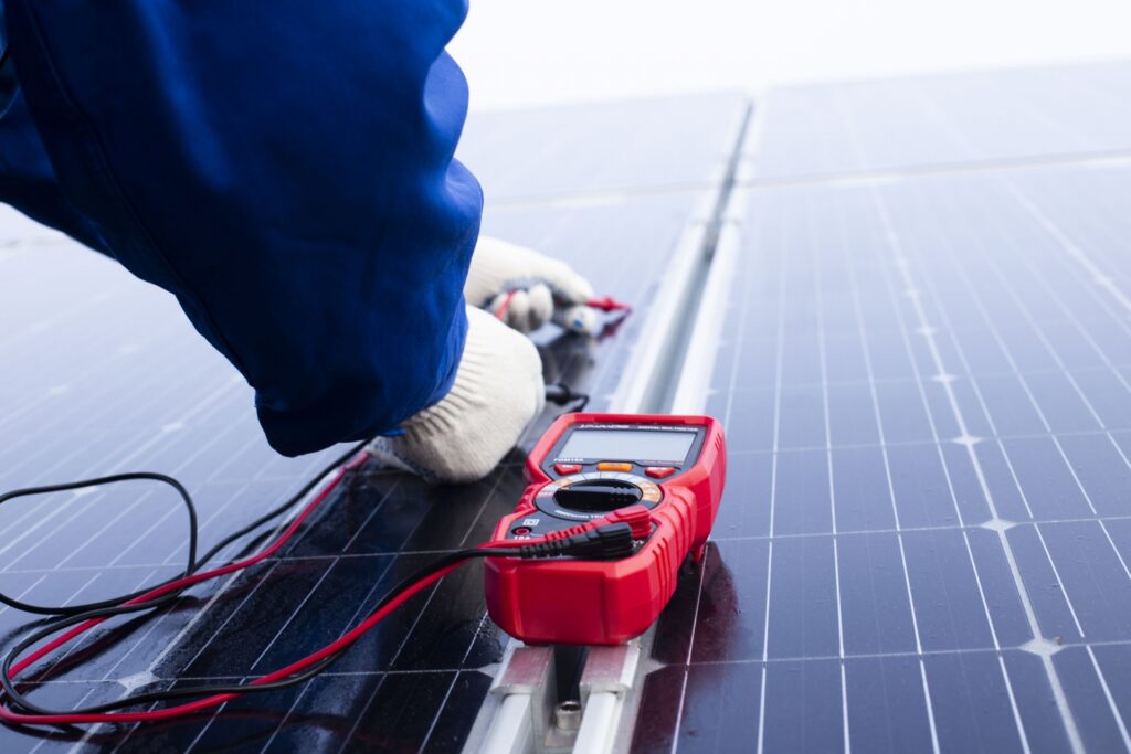 太陽電池モジュールの電力量をはかっている写真